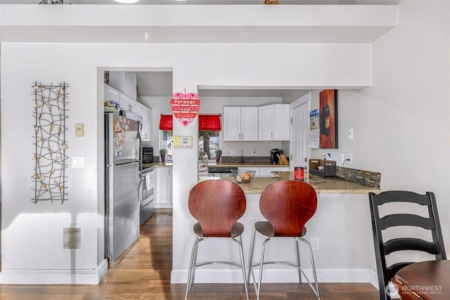 kitchen featuring a peninsula, dark wood-type flooring, visible vents, white cabinets, and appliances with stainless steel finishes