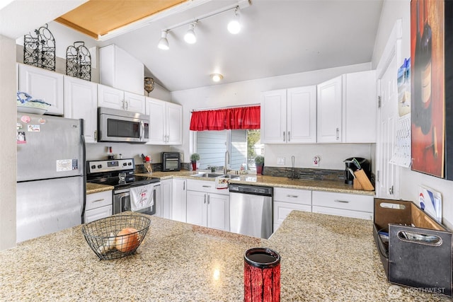 kitchen with white cabinetry, appliances with stainless steel finishes, vaulted ceiling, and a sink