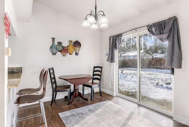 dining space featuring a notable chandelier, baseboards, and wood finished floors