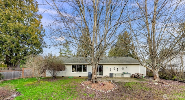 back of property with a yard, crawl space, a patio area, and a fenced backyard