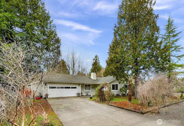 single story home featuring driveway, a chimney, and an attached garage