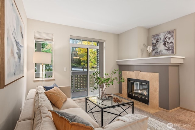 living room featuring a tiled fireplace and carpet flooring