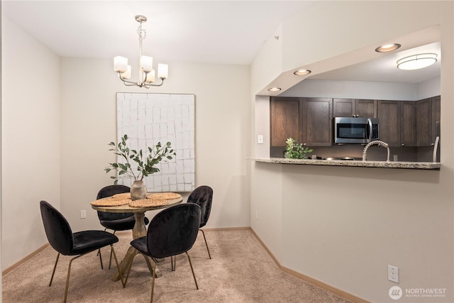 dining area featuring light colored carpet and a chandelier