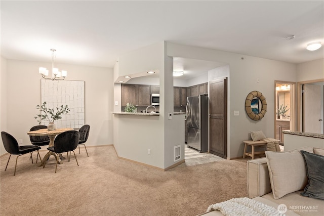 interior space featuring an inviting chandelier, sink, and light carpet