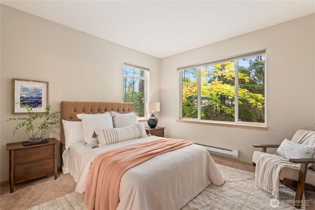 carpeted bedroom featuring a baseboard heating unit