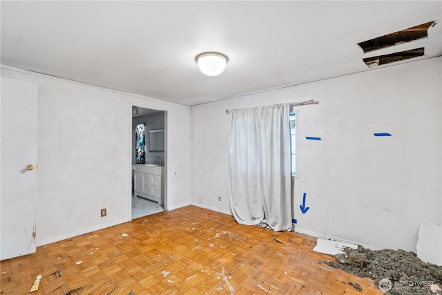 unfurnished bedroom with baseboards, a sink, and ensuite bathroom