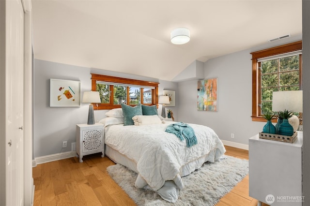 bedroom with vaulted ceiling and light hardwood / wood-style floors