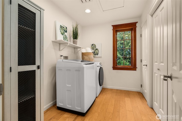 laundry room with light hardwood / wood-style flooring and washer and dryer