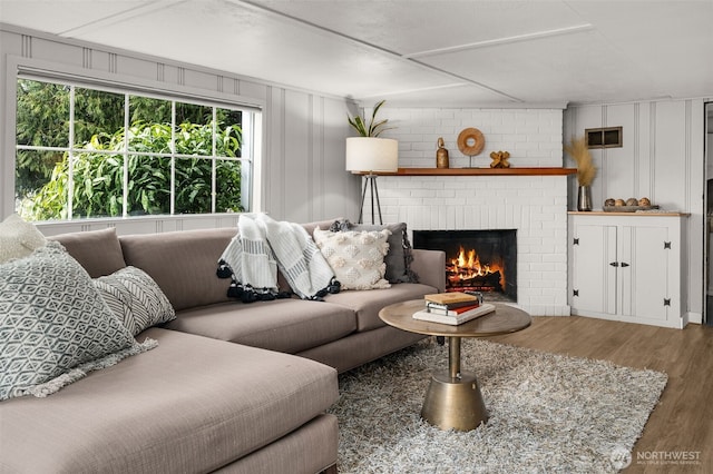 living room featuring a brick fireplace and hardwood / wood-style flooring