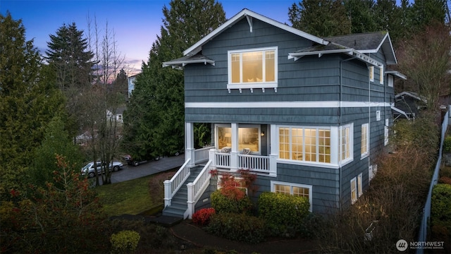 back house at dusk with covered porch