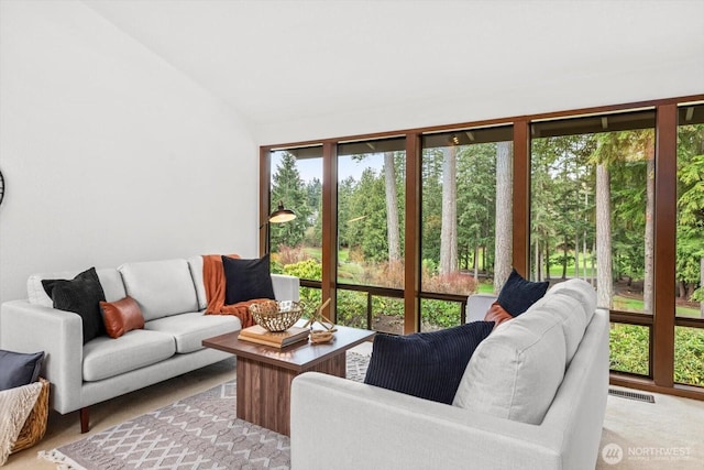 living area featuring visible vents and vaulted ceiling