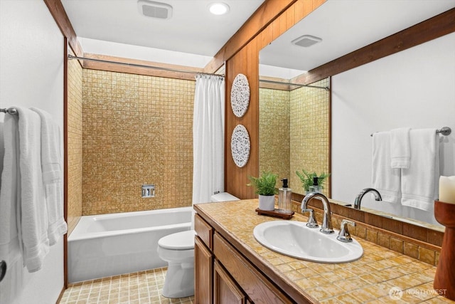 full bathroom featuring visible vents, shower / bath combo with shower curtain, toilet, and vanity