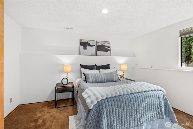 carpeted bedroom with visible vents and a textured ceiling