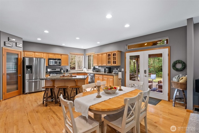 dining space with recessed lighting, light wood-style flooring, and french doors