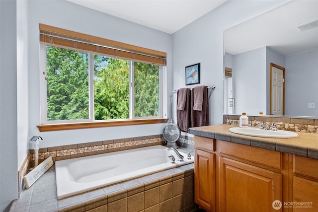 full bath with a garden tub, vanity, and visible vents