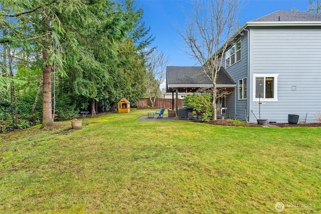 view of yard featuring a patio area, a playground, and fence