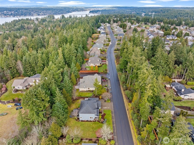 birds eye view of property featuring a residential view, a water view, and a view of trees