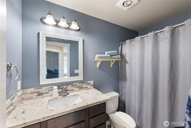 bathroom with tasteful backsplash, vanity, toilet, and curtained shower