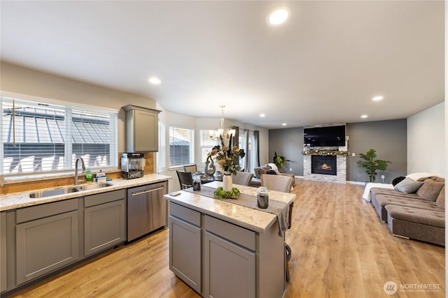 kitchen featuring pendant lighting, sink, gray cabinets, dishwasher, and a center island