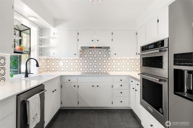 kitchen with dishwashing machine, sink, and white cabinets