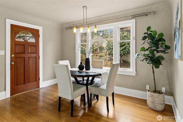 dining area with baseboards and wood finished floors