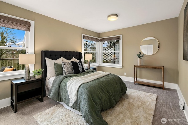 bedroom featuring multiple windows, baseboards, and carpet flooring