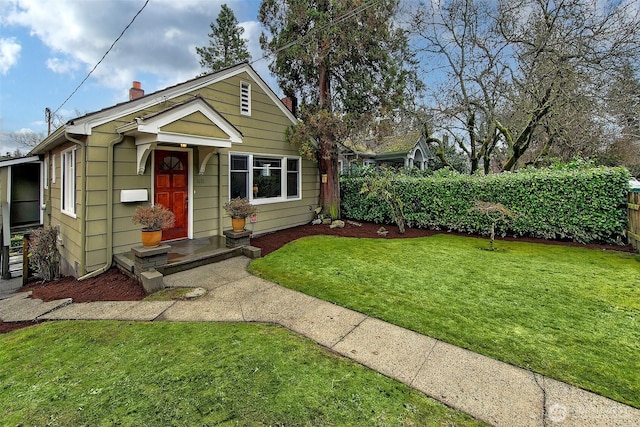 bungalow-style house featuring fence and a front lawn