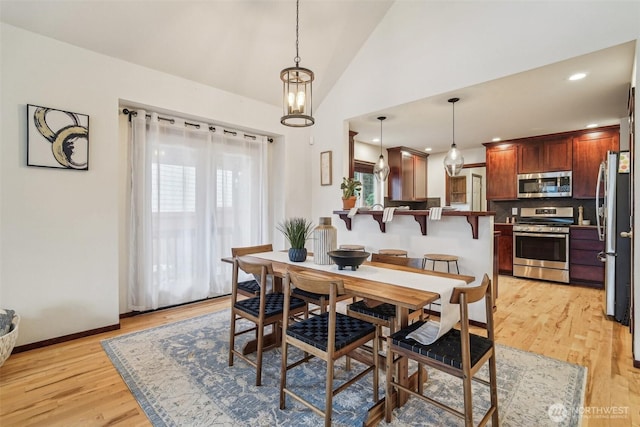 dining area featuring recessed lighting, baseboards, lofted ceiling, and light wood-style flooring