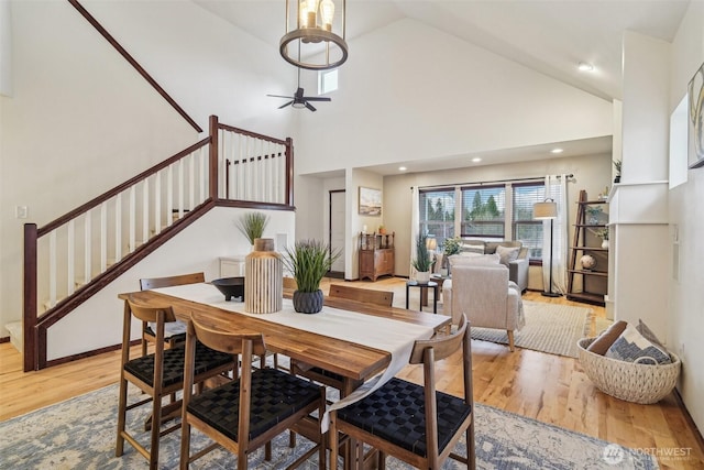 dining space featuring ceiling fan, stairway, recessed lighting, light wood-style floors, and high vaulted ceiling