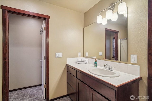 bathroom with baseboards, vanity, and tile patterned flooring