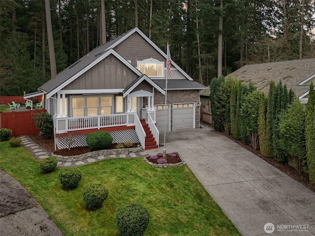 rustic home with board and batten siding, a porch, concrete driveway, a front yard, and a garage