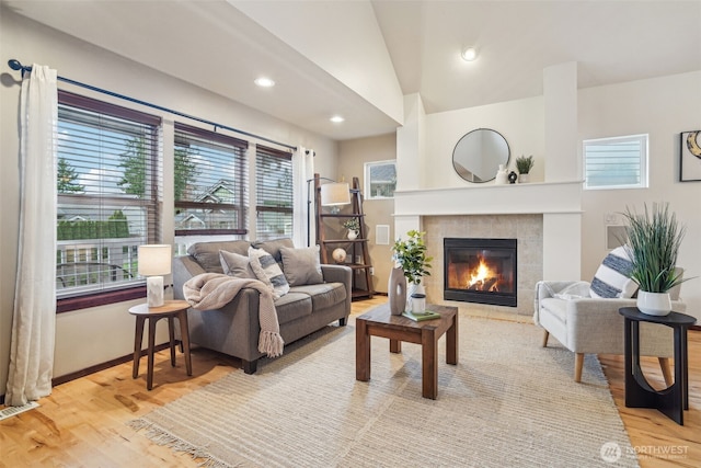 living area with visible vents, recessed lighting, light wood-style floors, a fireplace, and lofted ceiling