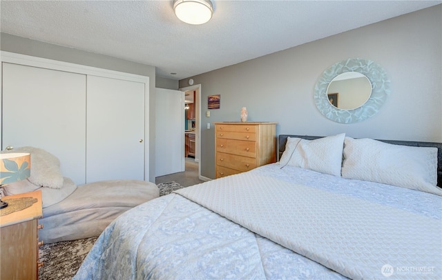 carpeted bedroom featuring a textured ceiling and a closet