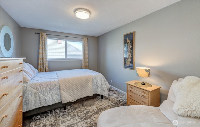 carpeted bedroom featuring a textured ceiling and baseboards