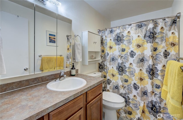 full bath with curtained shower, vanity, and toilet