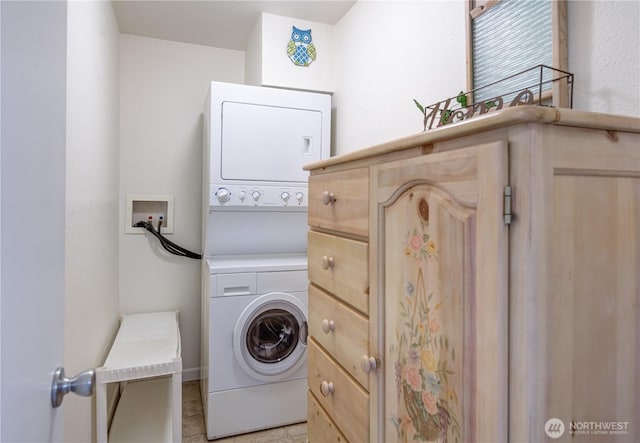 clothes washing area with stacked washer and dryer and cabinet space