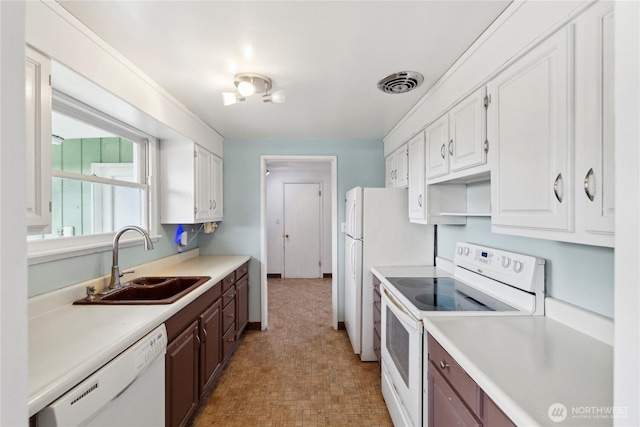 kitchen featuring dark brown cabinetry, sink, white cabinets, and white appliances