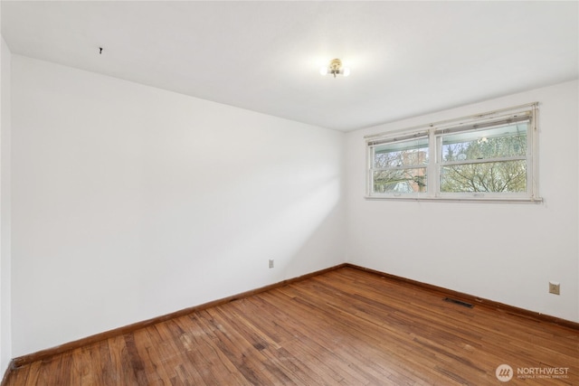 spare room featuring wood-type flooring