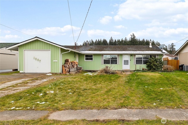 ranch-style house with a garage, a front lawn, and central air condition unit