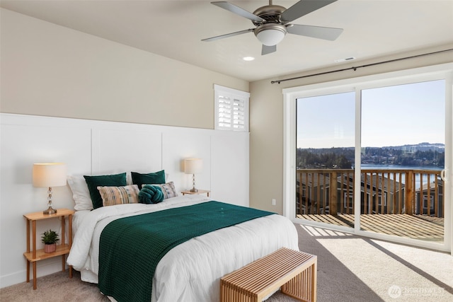 bedroom with access to outside, a water view, ceiling fan, and carpet