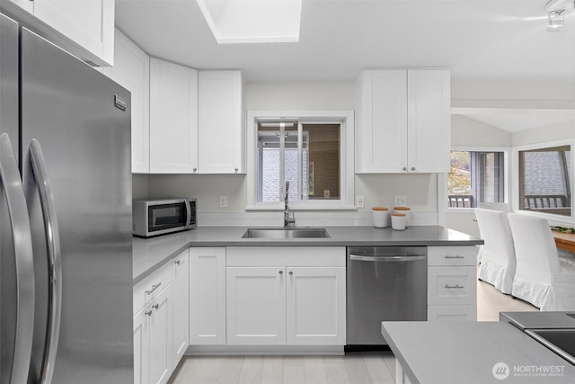 kitchen featuring appliances with stainless steel finishes, sink, and white cabinets