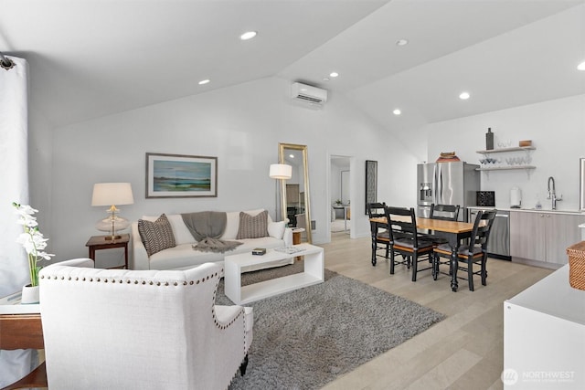 living room with lofted ceiling, sink, a wall mounted air conditioner, and light hardwood / wood-style floors