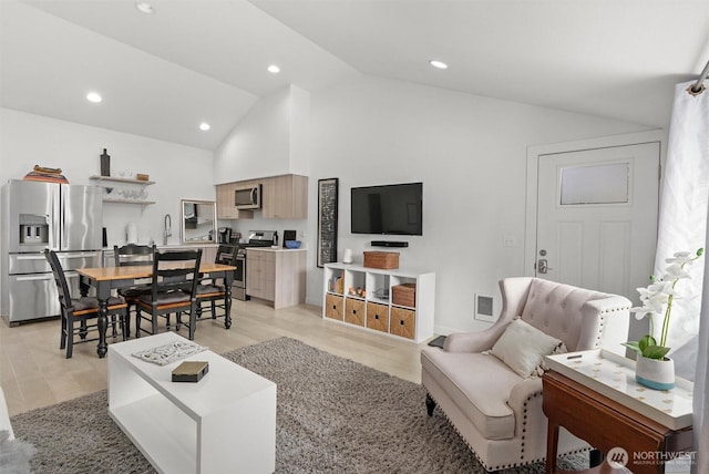 living room featuring light hardwood / wood-style flooring and high vaulted ceiling