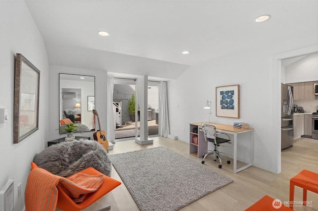 office featuring lofted ceiling and light hardwood / wood-style flooring