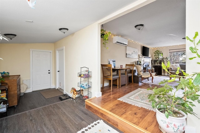 interior space with dark wood-type flooring and a wall mounted AC