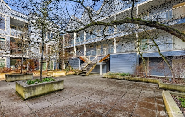 view of property's community with a patio area and stairs