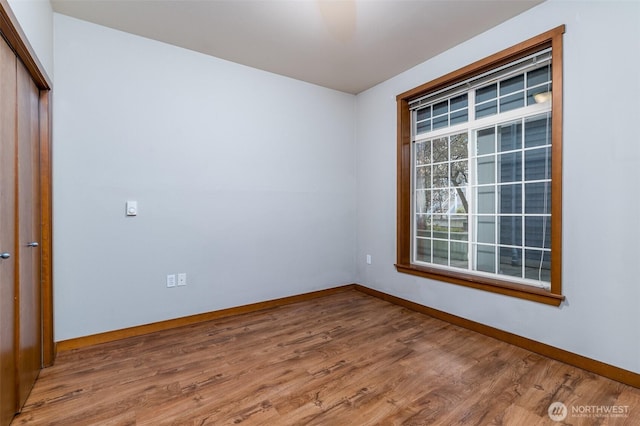 spare room featuring wood finished floors and baseboards