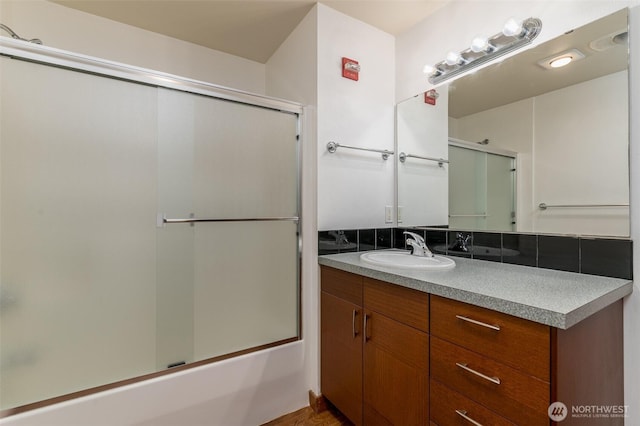 bathroom featuring bath / shower combo with glass door and vanity