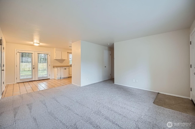 unfurnished living room with light carpet, light tile patterned floors, and french doors