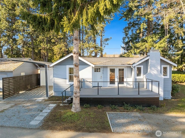 view of front facade featuring a wooden deck and french doors